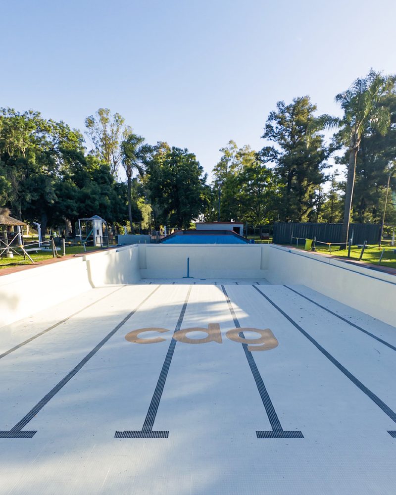 Pileta olímpica de un club con carriles y logo, revestida con venecitas Neobind