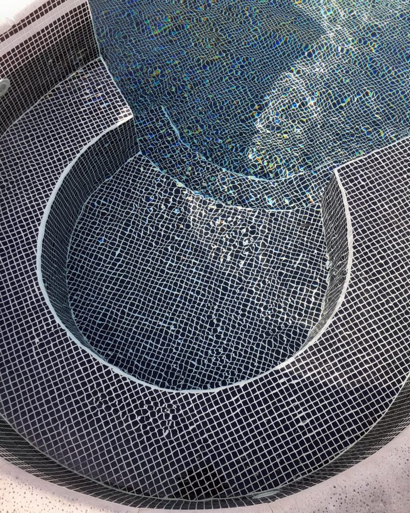 Jacuzzi circular revestido con venecitas Neobind negras
